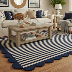 Close up of navy blue and ivory scalloped border hand tufted area rug in a living room highlighting thick plush pile texture