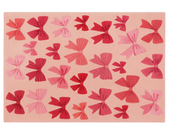 Blush holiday rug decorated with red and pink bows.
