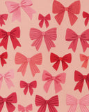 Premium wool pink Christmas rug featuring festive bow motifs.