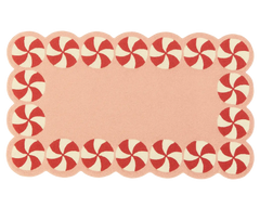 Blush pink holiday rug featuring candy swirl design.