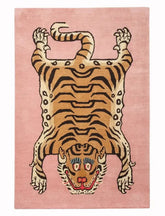 Pink handwoven rug with a modern stylized tiger motif, featuring bold stripes and blue eye accents