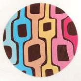 Colorful geometric round wool area rug with blue pink yellow and brown shapes for a living room, 8ft round size