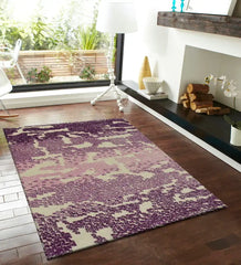 Modern living room with purple and beige abstract gradient textured area rug on hardwood floor