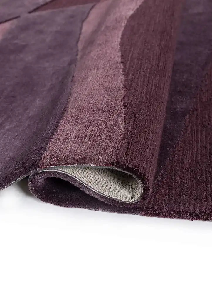 Purple modern plum wave textured rug with layered fabric detail on white background