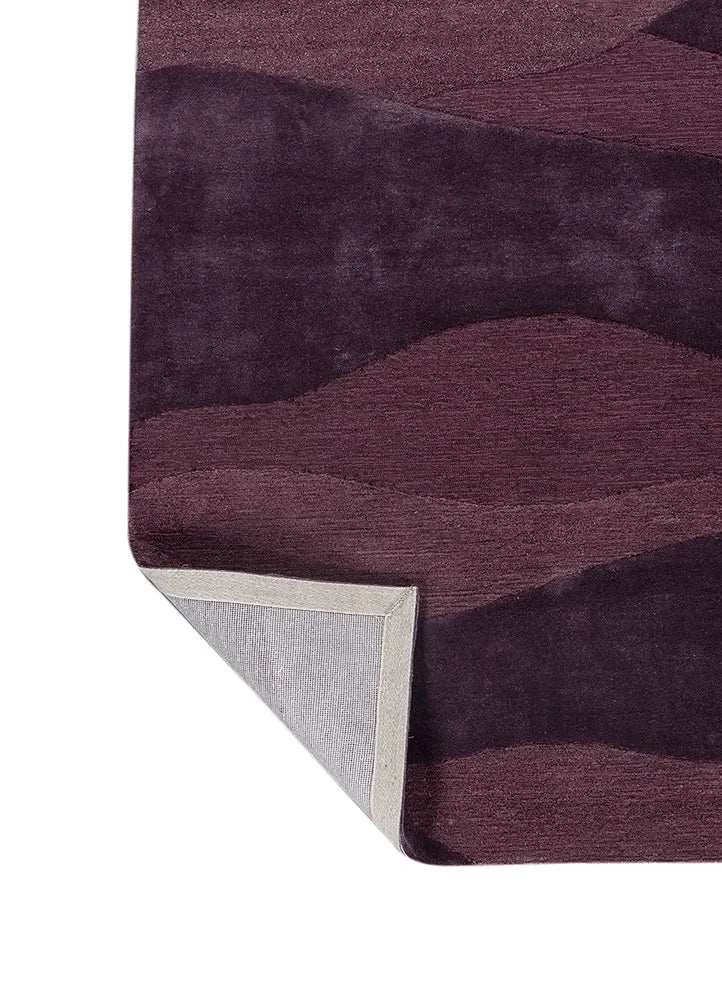 Purple modern rug with wave patterns and textured surface, one corner folded