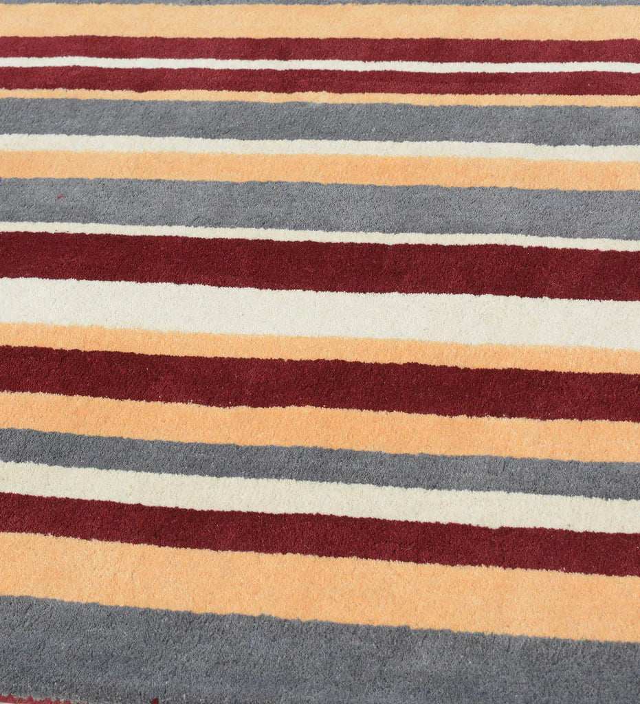 Modern hand-tufted rug in earthy rust red and mustard yellow hues.