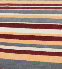 Modern hand-tufted rug in earthy rust red and mustard yellow hues.