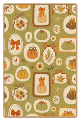 Harvest rug with pumpkins, bows, and leaves on green background.