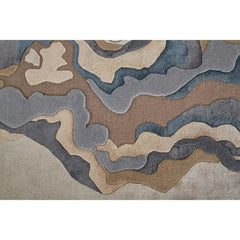 Close-up of Seraphic Bloom luxury handwoven rug with abstract layered pattern in beige, brown, and blue tones