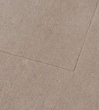Close-up of solid beige minimalist hand-tufted rug with subtle texture and clean edges