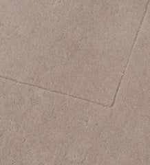 Close-up of solid beige minimalist hand-tufted rug with subtle texture and clean edges