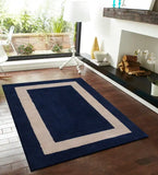 Modern living room with solid blue and beige midnight rug on wooden floor by fireplace and large window