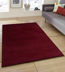 Deep maroon wool rug with subtle embossed rectangular border