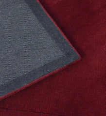 Minimalist maroon wool rug with embossed detailing