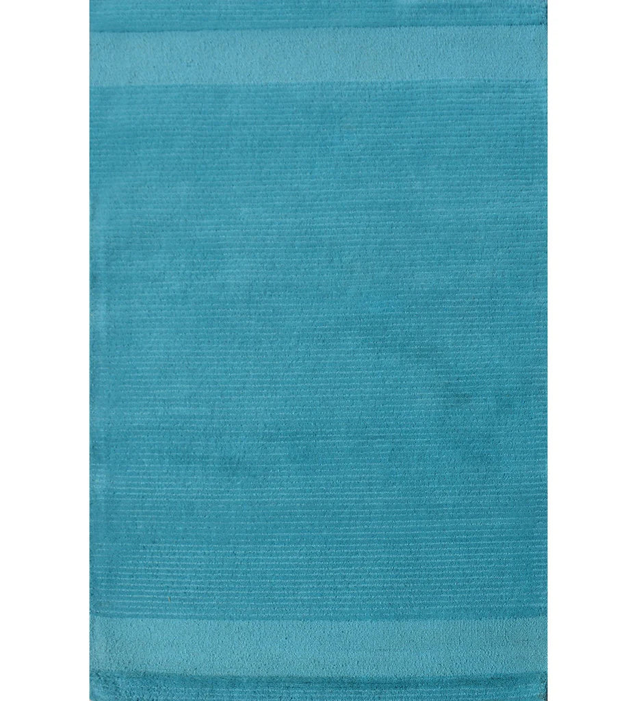 Solid teal hand-tufted wool rug with minimalist linear design