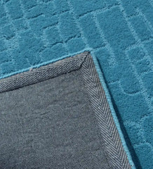 Modern solid teal rug with subtle geometric detailing