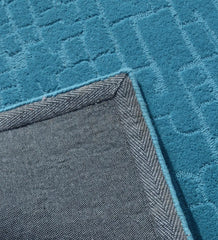 Modern solid teal rug with subtle geometric detailing