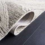 Close-up of Stone Drift hand-tufted wool rug with textured geometric design on dark hardwood floor