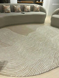 Designer oval area rug with flowing white lines and neutral base.