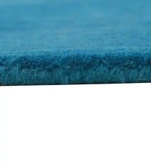 Minimalist teal wool rug with clean border pattern