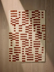 Terracotta modern geometric handwoven rug on wooden floor, luxury decorative area carpet