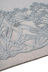 Close-up of Tranquil Harmony hand-tufted rug with textured floral design in soft gray and beige