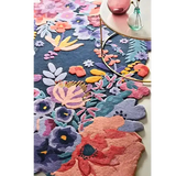 Luxury floral handwoven rug in vibrant colors under a round glass table with decorative vases