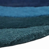 Close-up of luxury handwoven rug with horizontal blue and teal color stripes and soft texture