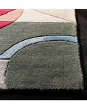 Close-up of luxury handwoven high-pile rug with geometric pattern in muted red, beige, green, and blue at Mannat Rugs