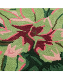 Close-up of a luxury handwoven rug with green, pink, and maroon abstract floral design