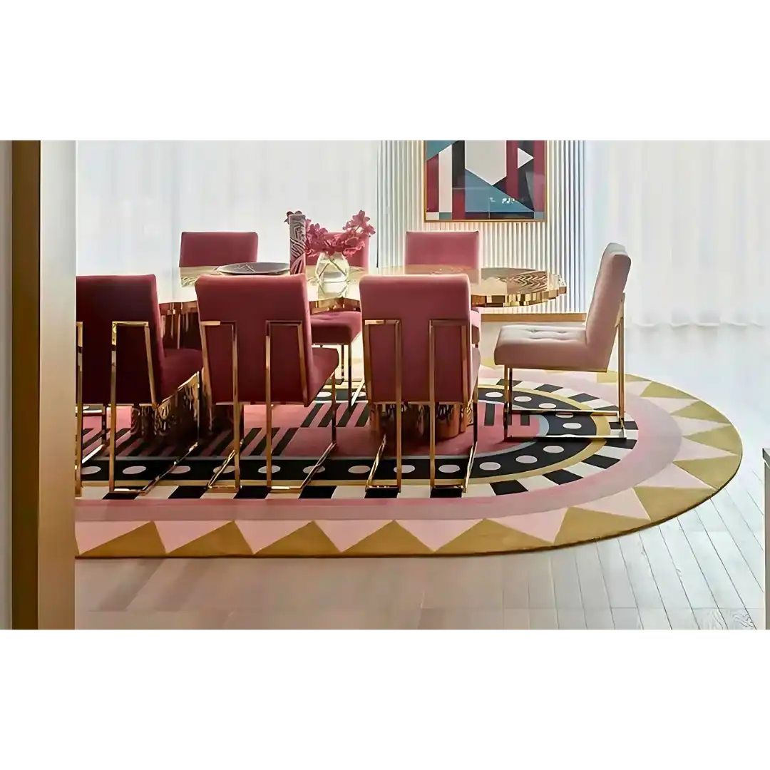 Luxury dining room with gold and pink chairs around a round gold table on a colorful geometric area rug