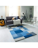 Modern living room with a blue geometric patchwork rug, gray sofa, acoustic guitar, and minimalist decor