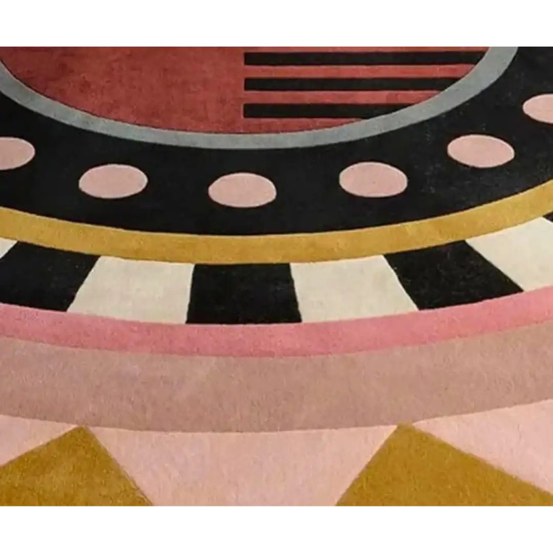 Close-up of luxury handwoven rug with geometric design in black, pink, gold, and red colors