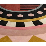 Close-up of luxury handwoven rug with geometric design in black, pink, gold, and red colors