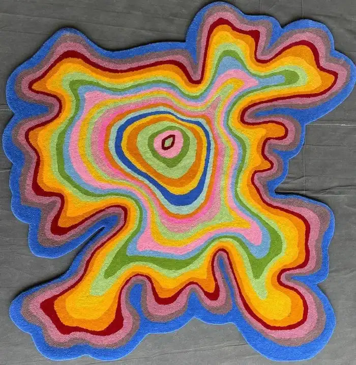 Colorful irregular hand-tufted rug with vibrant concentric wavy patterns in blue, yellow, green, and pink