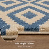 Close-up of a hand-tufted wool rug with a blue and cream geometric diamond pattern, showing a 12mm pile height and a circular inset detail of the tufted edge.