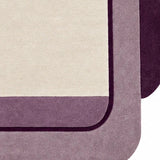Close-up of hand-tufted purple and mauve wool rug with ivory geometric border for bedroom