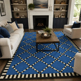 A large blue area rug with a black and white geometric trellis pattern, styled in a modern living room setting with a wooden coffee table, white sofas, and a fireplace in the background.