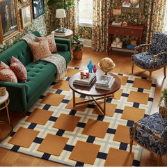 Living room with green sofa, patterned rug, and decorative items.