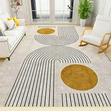 Modern living room with a white couch, rocking chair, green plant, and geometric patterned rug in gold and black