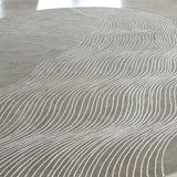 Round gray rug with wavy pattern on a light-colored floor