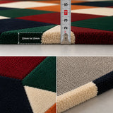 A close-up collage of a geometric area rug with a measuring ruler showing a 12mm to 15mm thickness. The rug features large color blocks of deep red, forest green, navy blue, cream, and orange, with a textured pile shown in detail.