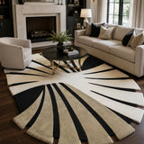 A large modern area rug with a bold sunburst or fan-like geometric pattern in beige, cream, and black, styled in a contemporary living room with a sofa, armchair, coffee table, and fireplace.