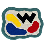 Abstract color block rug with wavy teal border, yellow, blue, red shapes, and black zigzag design