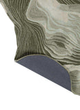 Hand-tufted woolen rug with abstract curved design in shades of green and beige, corner lifted