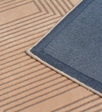 Beige modern geometric pattern rug with a visible blue denim edge backing
