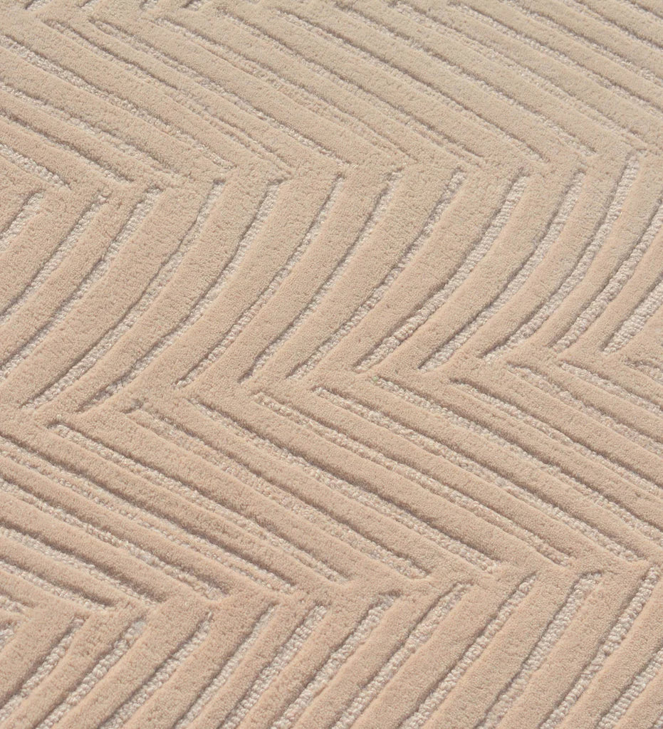 Minimalist beige rug with subtle chevron texture.