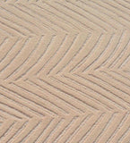 Beige textured rug with handwoven chevron pattern enhancing luxury home decor