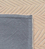 Beige textured chevron pattern luxury rug with gray fabric backing and stitched edge from Mannat Rugs