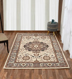 Beige and brown traditional ornate area rug on wooden floor with gray ottoman and chair